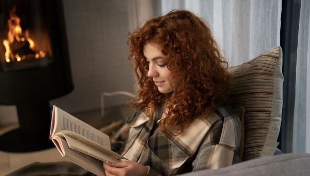 Girl reading a book while sitting at home