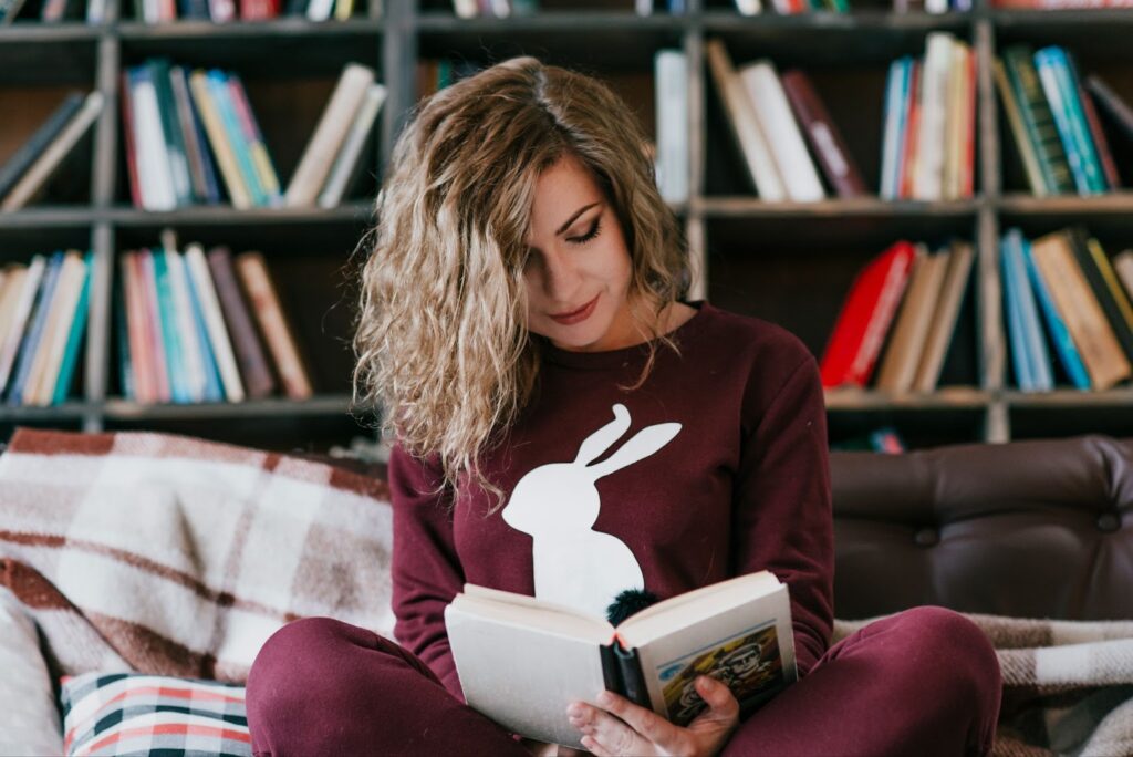 Woman reading a book on a sofa