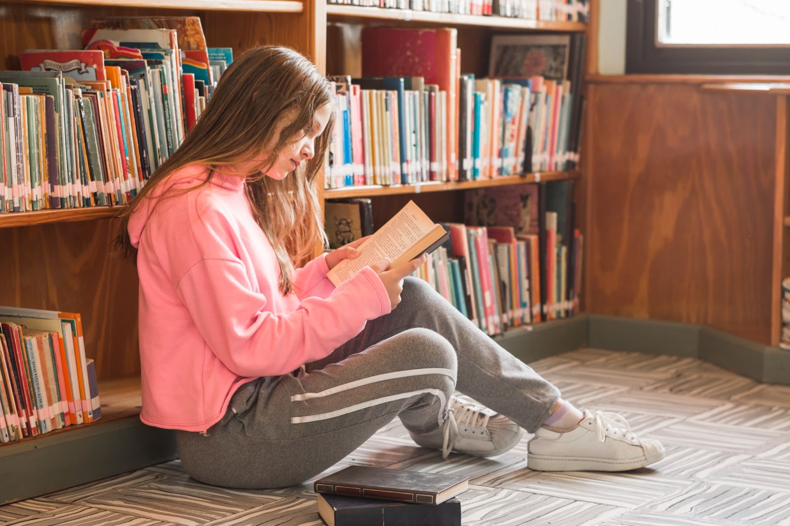 Girl reading near bookcase