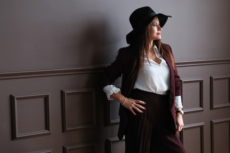 a young woman clad in a classic outfit, donning a romantically styled white blouse and a wide-brimmed hat